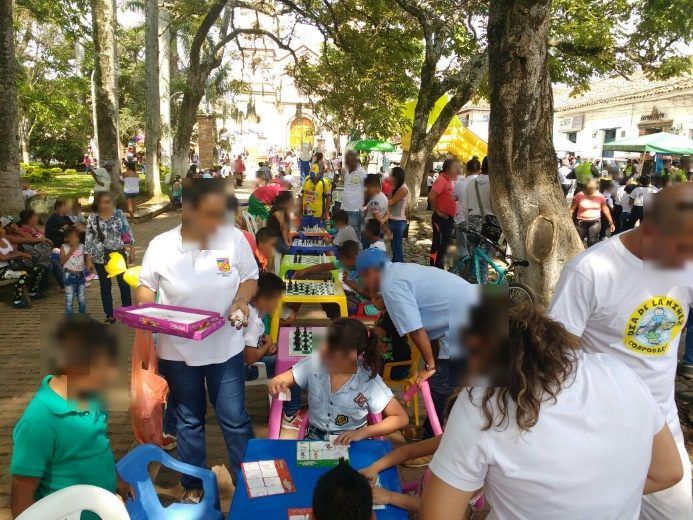 Mesas de ajedrez en el parque principal con niños jugando