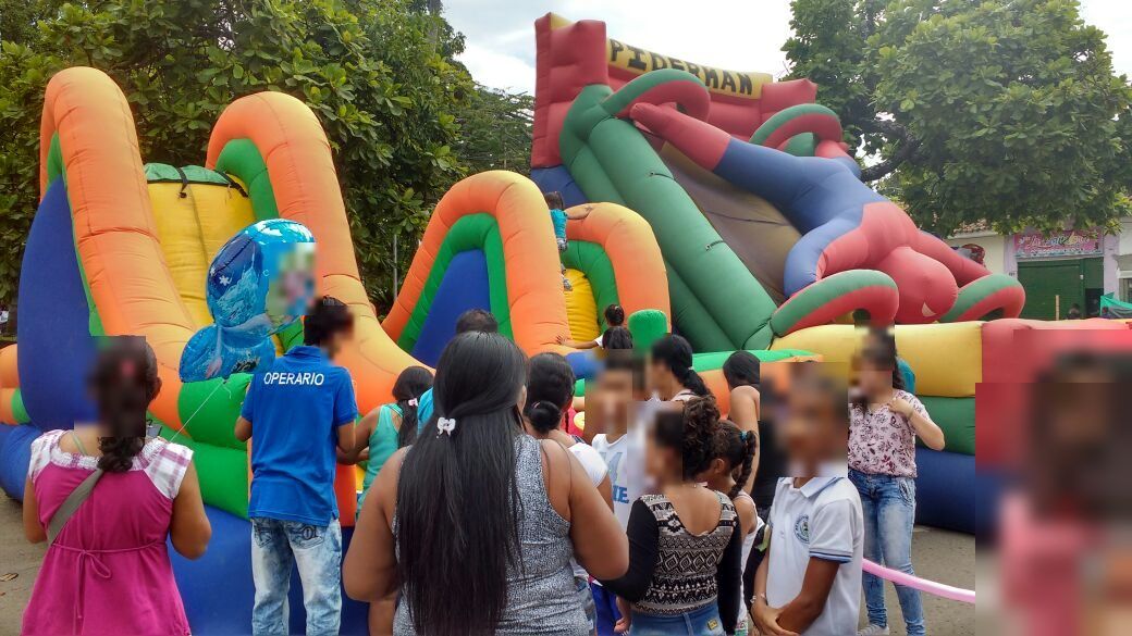 Niños y niñas haciendo fila frente a los inflables
